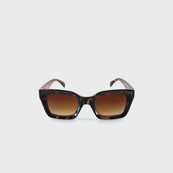 Karimás, enyhén cicás dizájnos, barna színű műanyag keretes napszemüveg.