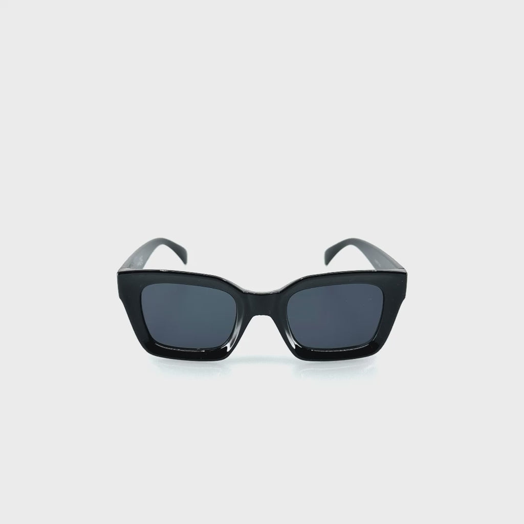 Karimás, enyhén cicás dizájnos, fekete színű műanyag keretes napszemüveg.