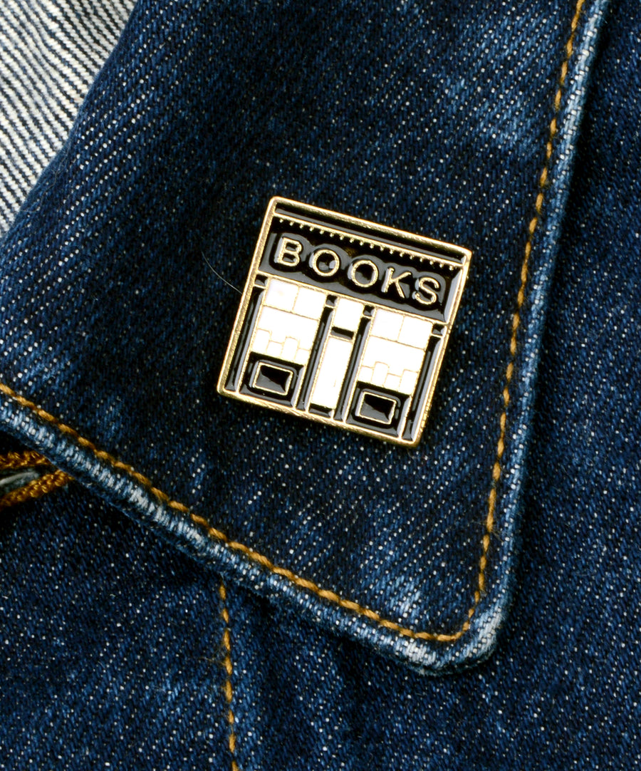 Könyvesbolt kirakatát ábrázoló, pin jellegű kitűző.